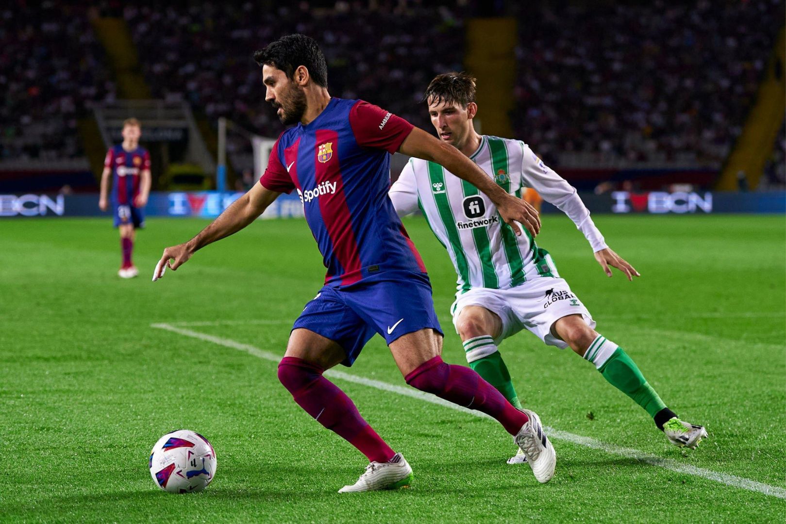 Ilkay Gundogan of FC Barcelona competes for the ball with Juan Miranda of Real Betis