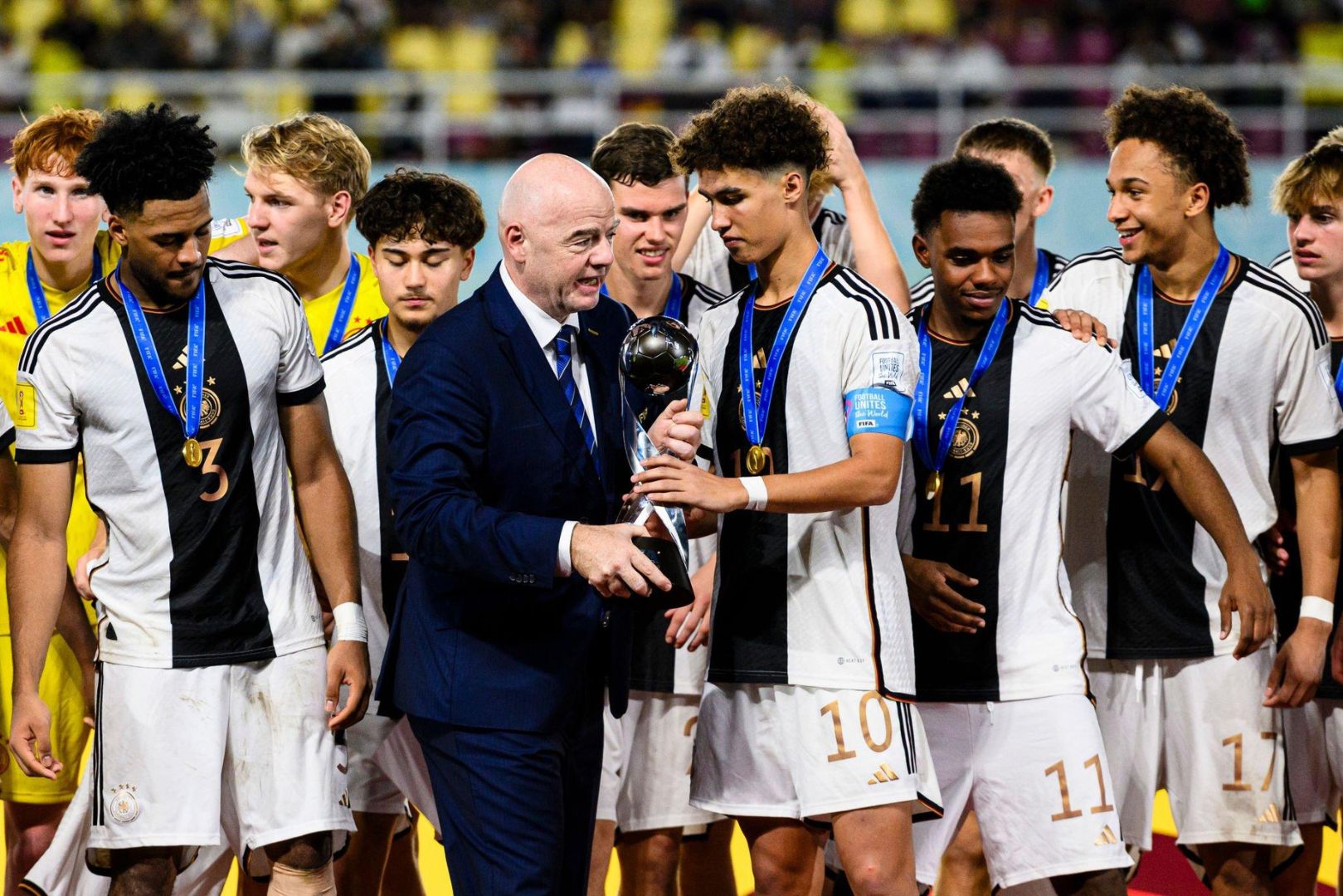 SURAKARTA, INDONESIA - DECEMBER 2: Noah Darvich of Germany (R) receives by the hands of FIFA president Gianni Infantino (L) the Champions trophy during FIFA U-17 World Cup Final match between Germany and France at Manahan Stadium on December 2, 2023 in Surakarta, Indonesia.