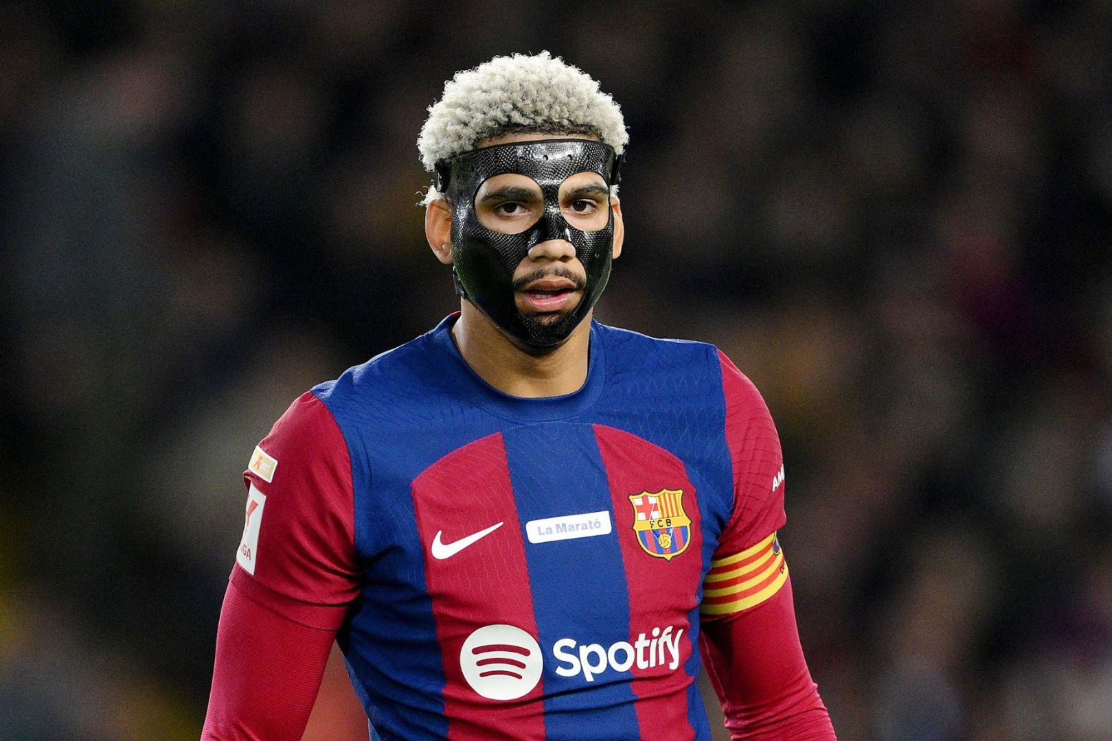 BARCELONA, SPAIN - DECEMBER 10: Ronald Araujo of FC Barcelona looks on whilst wearing a protective face covering during the LaLiga EA Sports match between FC Barcelona and Girona FC at Estadi Olimpic Lluis Companys on December 10, 2023 in Barcelona, Spain.