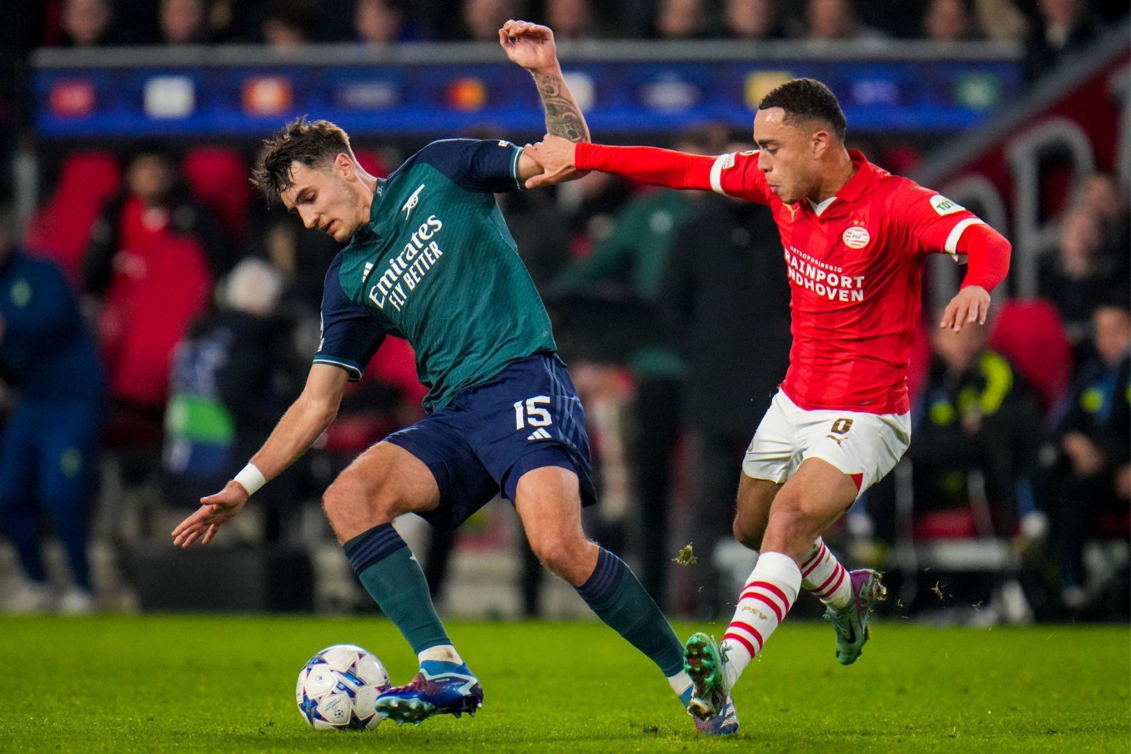 EINDHOVEN, NETHERLANDS - DECEMBER 12: Jakub Kiwior of Arsenal is challenged by Sergino Dest of PSV during the UEFA Champions League Group B match between PSV and Arsenal at the Phillips Stadion on December 12, 2023 in Eindhoven, Netherlands.