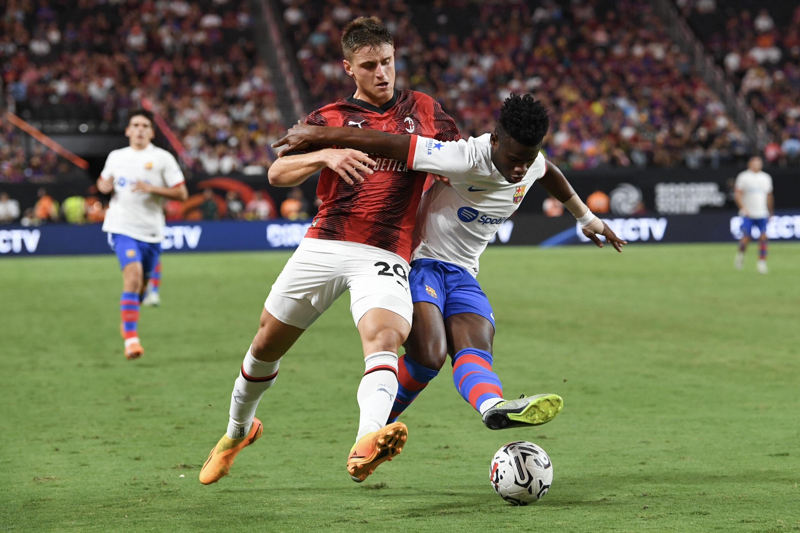 LAS VEGAS, NEVADA - AUGUST 01: Lorenzo Colombo #29 of AC Milan battles for the ball with Mika Faye #30 of FC Barcelona during the second half of a preseason friendly match during the 2023 Soccer Champions Tour at Allegiant Stadium on August 01, 2023 in Las Vegas, Nevada.