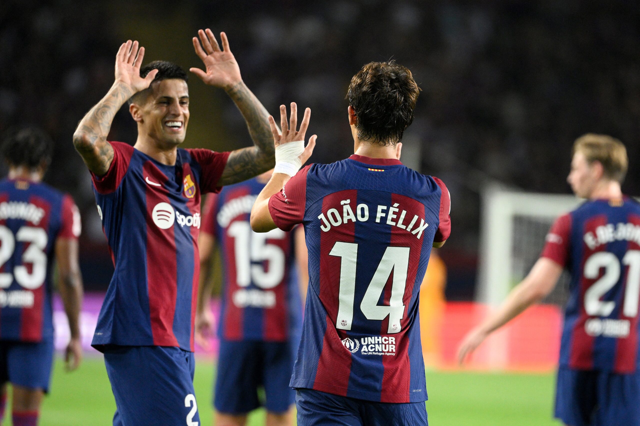 Barcelona's Portuguese forward #14 Joao Felix celebrates with Barcelona's Portuguese defender #02 Joao Cancelo after scoring his team's first goal during the Spanish Liga football match between FC Barcelona and Real Betis at the Estadi Olimpic Lluis Companys in Barcelona on September 16, 2023.