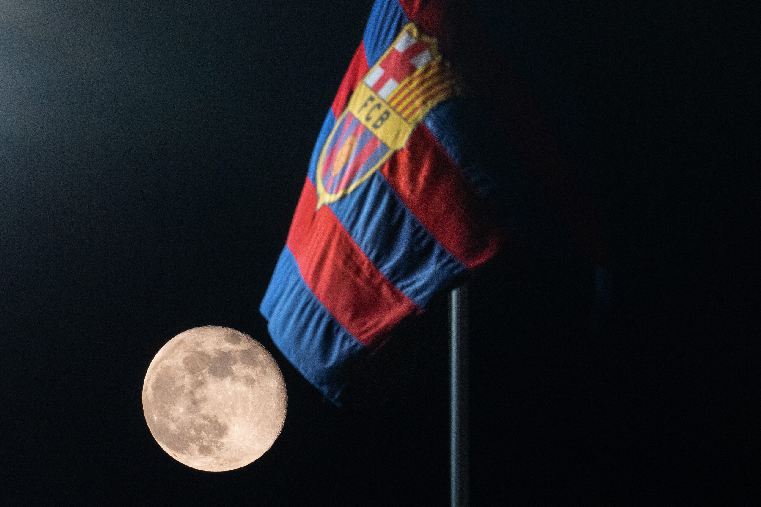 BARCELONA, SPAIN - NOVEMBER 28: A view of the moon alongside an FC Barcelona flag ahead of the UEFA Champions League match between FC Barcelona and FC Porto at Estadi Olimpic Lluis Companys on November 28, 2023 in Barcelona, Spain.