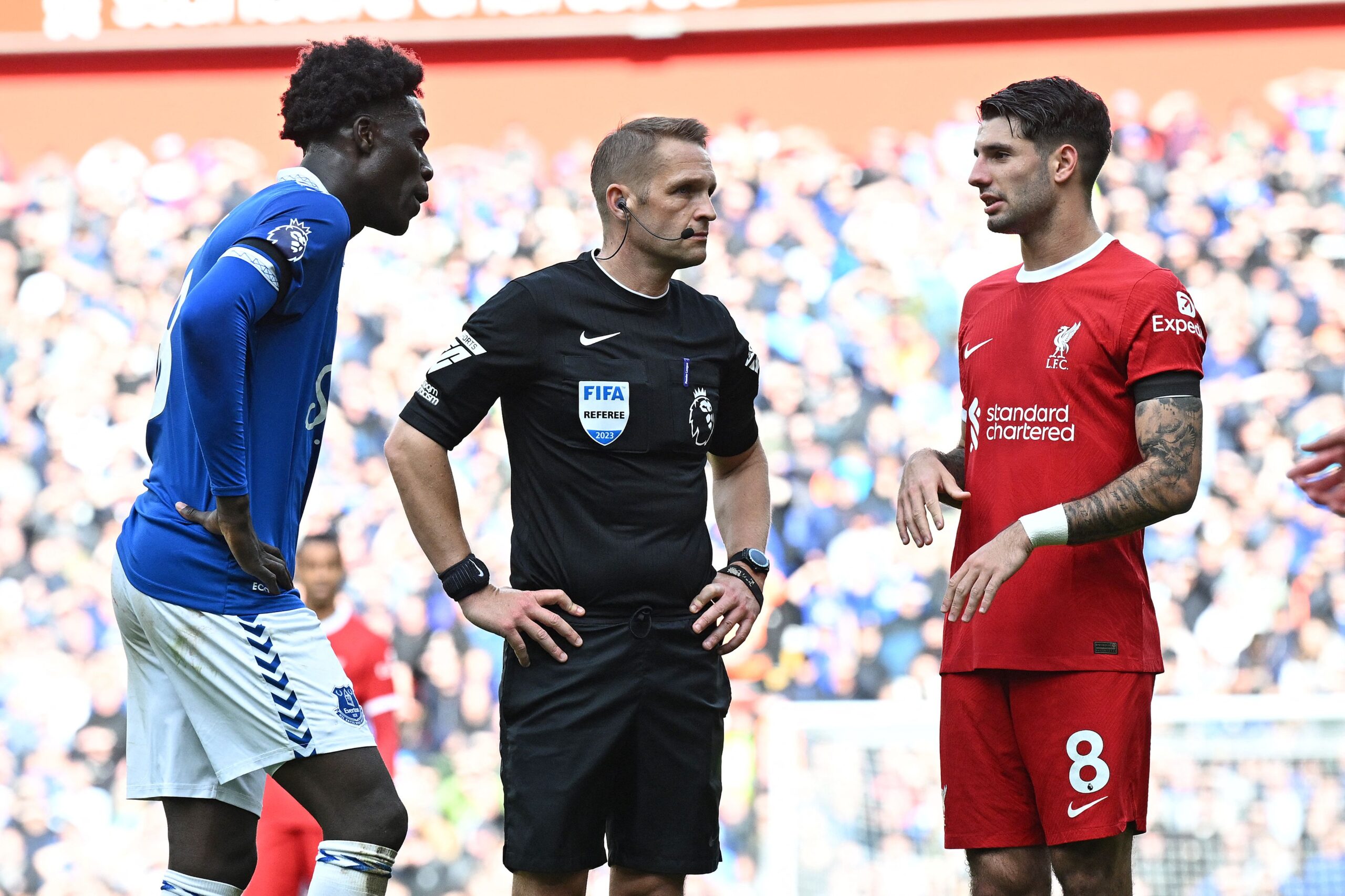Everton's Senegalese-born Belgian midfielder #08 Amadou Onana (L) and Liverpool's Hungarian midfielder #08 Dominik Szoboszlai (R) remonstrate with Referee Craig Pawson during the English Premier League football match between Liverpool and Everton at Anfield in Liverpool, north west England on October 21, 2023.