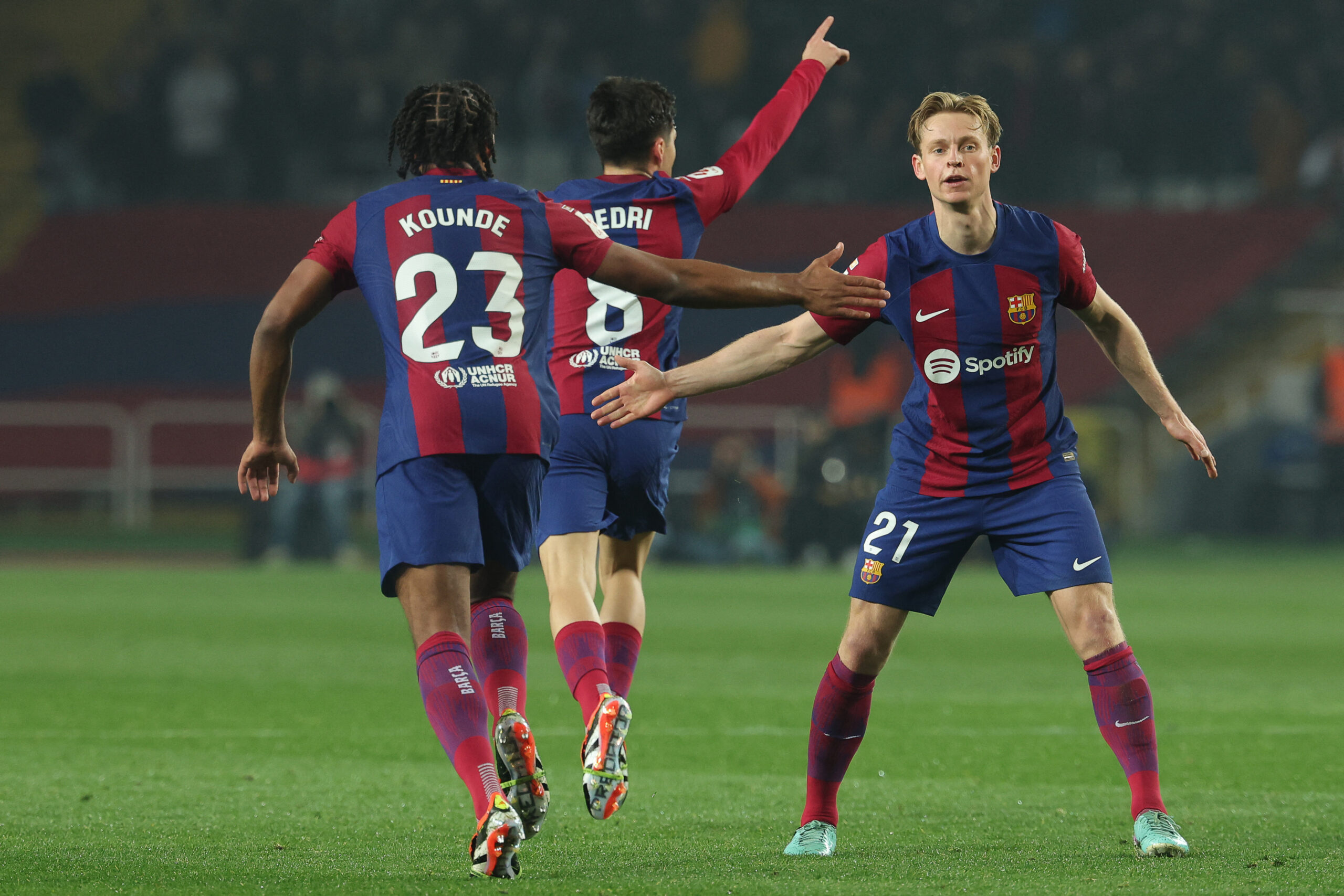 Barcelona's Spanish midfielder #08 Pedri celebrates with Barcelona's French defender #23 Jules Kounde and Barcelona's Dutch midfielder #21 Frenkie de Jong after scoring his team's second goal during the Spanish league football match between FC Barcelona and Villarreal CF at the Estadi Olimpic Lluis Companys in Barcelona on January 27, 2024.