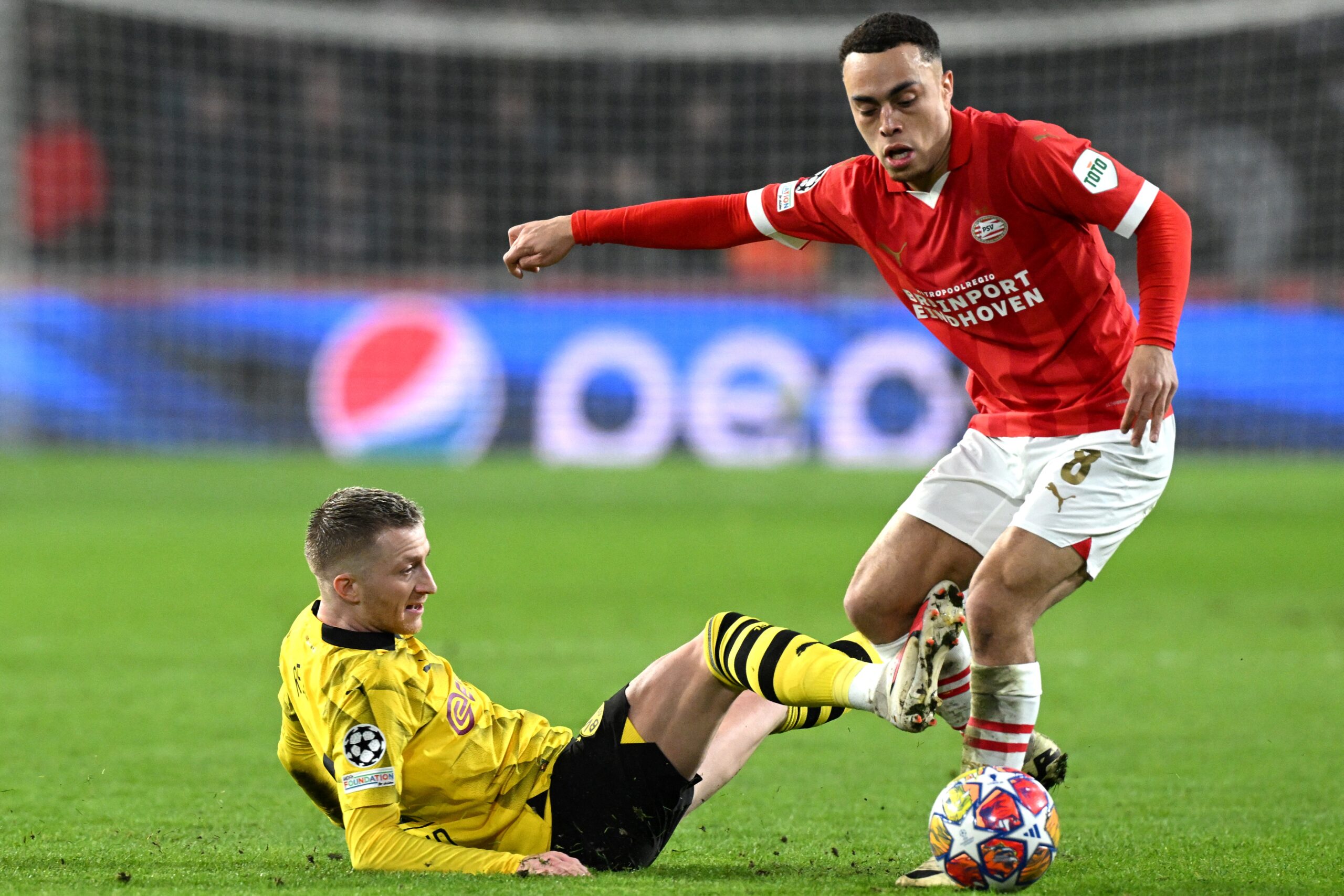Dortmund's German forward #11 Marco Reus (L) and PSV's US midfielder #08 Sergino Dest fight for the ball during the UEFA Champions League round of 16, first leg football match between against PSV Eindhoven and Borussia Dortmund at the The Philips Stadium, in Eindhoven on February 20, 2024.