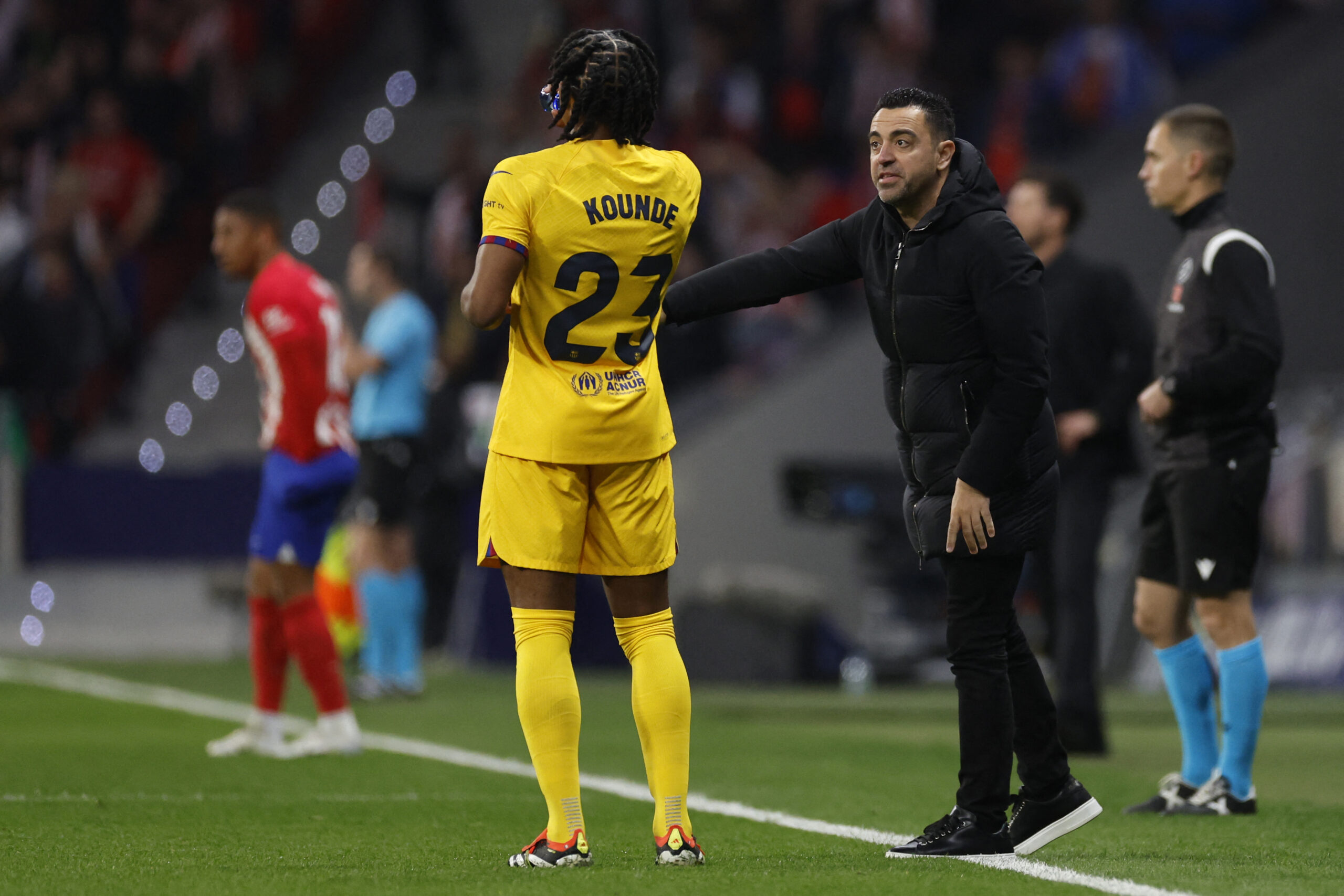 Barcelona's Spanish coach Xavi talks to Barcelona's French defender #23 Jules Kounde during the Spanish league football match between Club Atletico de Madrid and FC Barcelona at the Metropolitano stadium in Madrid on March 17, 2024.