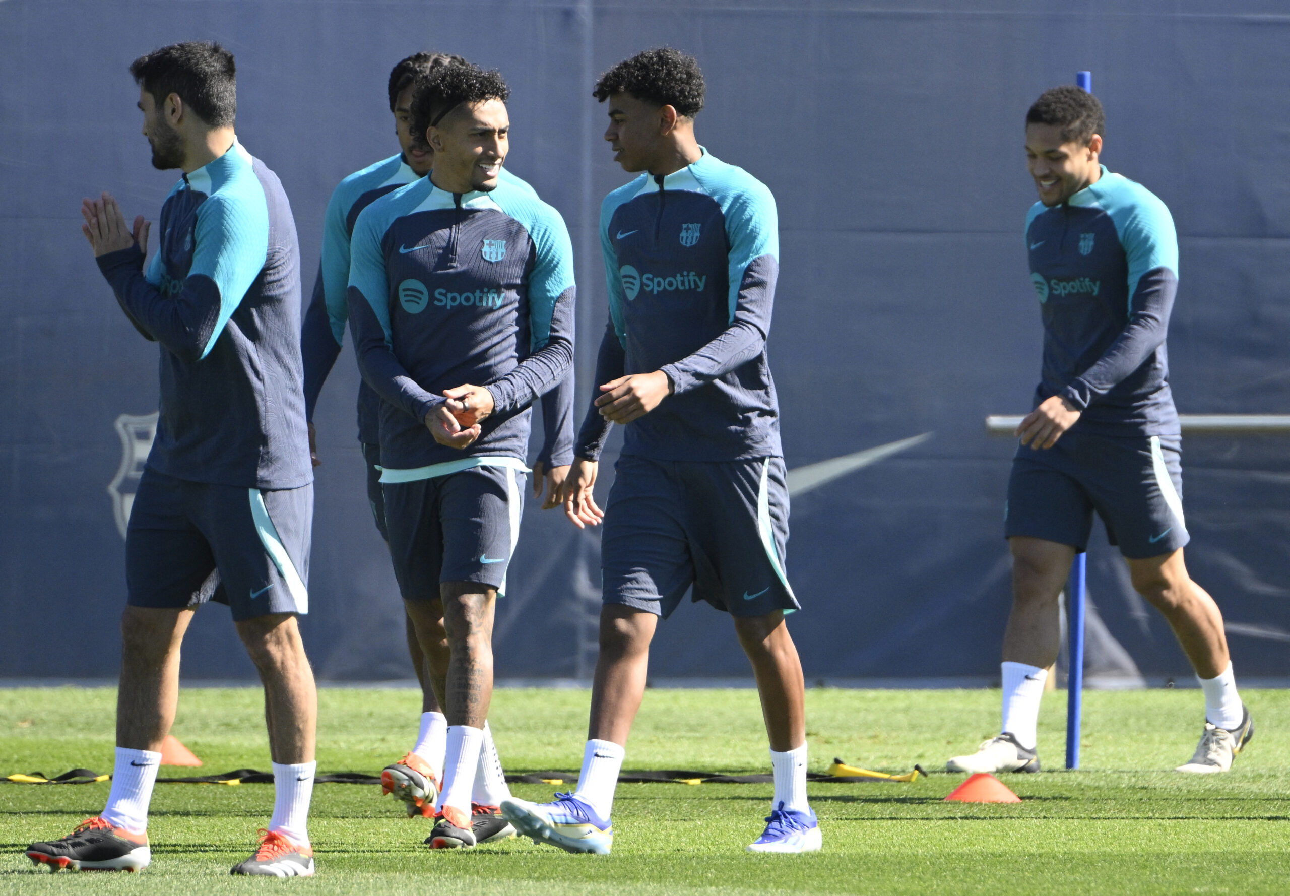 Barcelona's Brazilian forward #11 Raphinha and Barcelona's Spanish forward #27 Lamine Yamal talks as they attend a training session on the eve of their UEFA Champions League last 16 second leg football match against SSC Napoli at the training center in Barcelona on March 11, 2024.