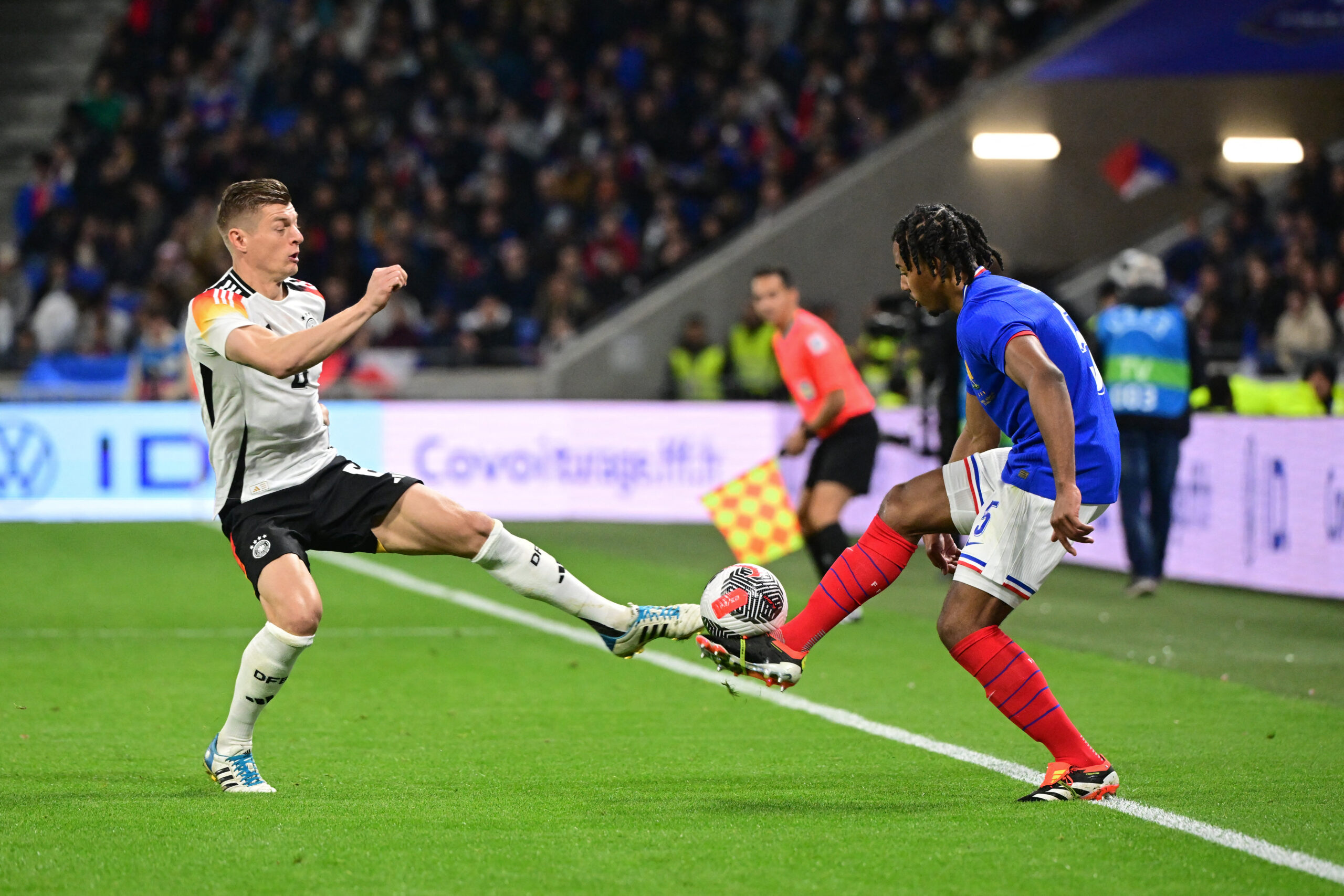 Germany's midfielder #08 Toni Kroos (L) and France's defender #05 Jules Kounde (R) fight for the ball during the friendly football match between France and Germany, at the Groupama Stadium in Decines-Charpieu, near Lyon, on March 23, 2024.