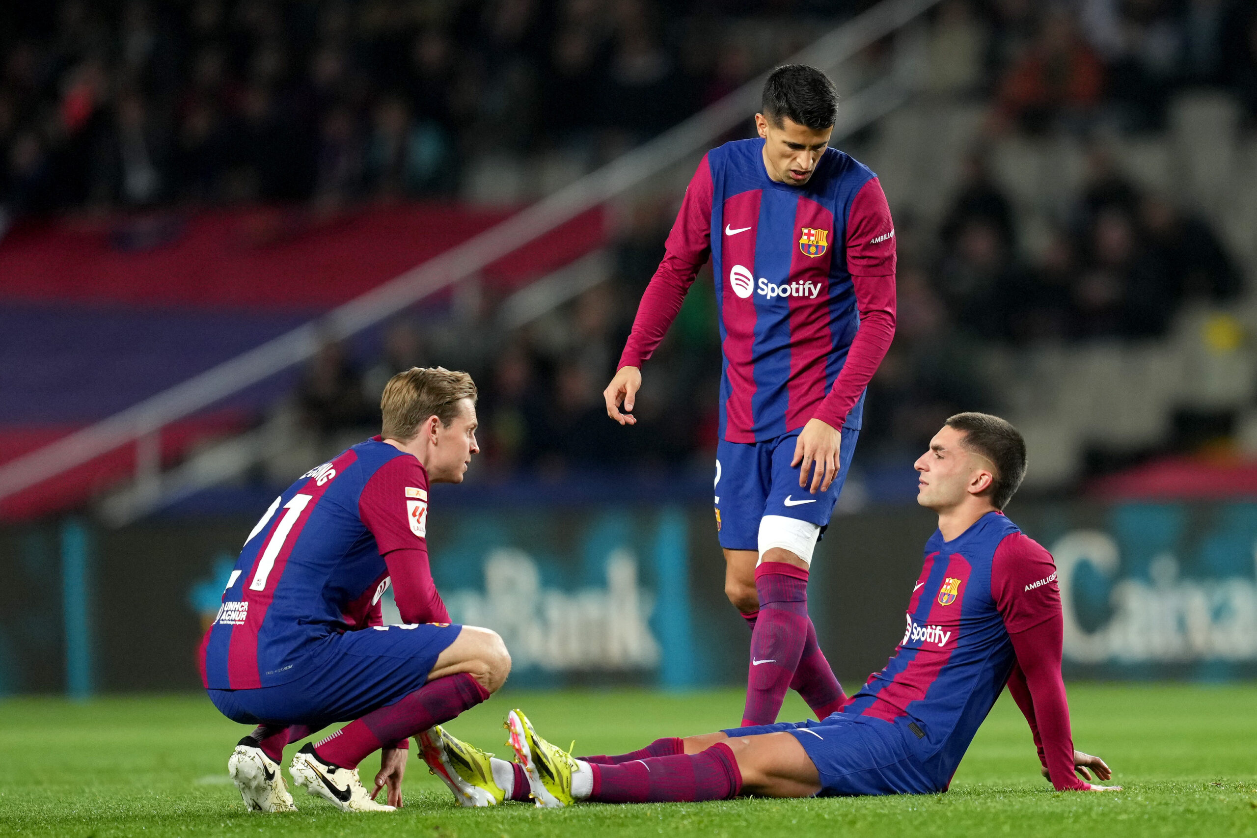 BARCELONA, SPAIN - JANUARY 31: Ferran Torres of FC Barcelona is consoled by teammates Frenkie de Jong and Joao Cancelo after suffering an injury during the LaLiga EA Sports match between FC Barcelona and CA Osasuna at Estadi Olimpic Lluis Companys on January 31, 2024 in Barcelona, Spain.