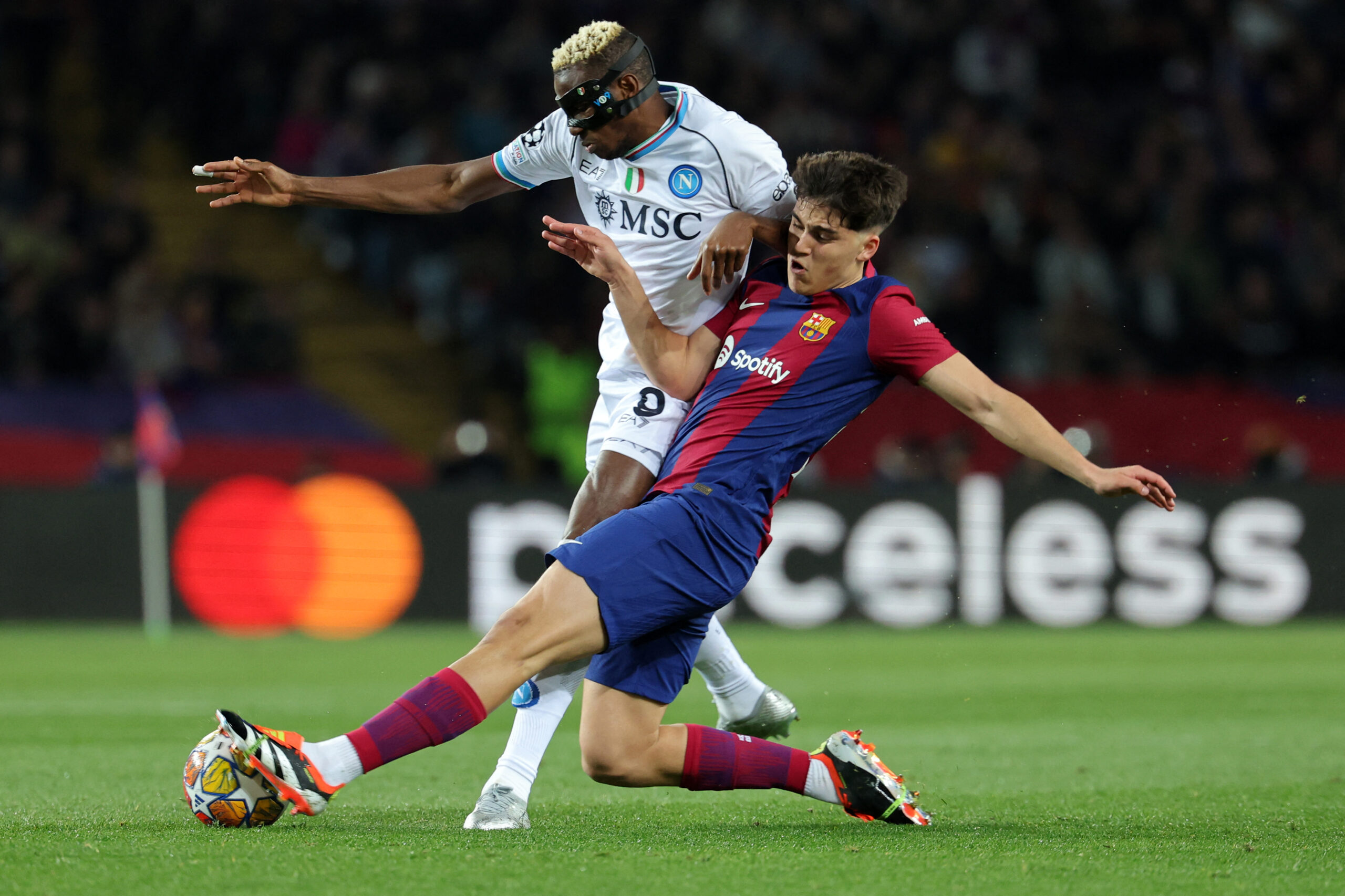 TOPSHOT - Barcelona's Spanish defender #33 Pau Cubarsi (R) and Napoli's Nigerian forward #09 Victor Osimhen vie for the ball during the UEFA Champions League last 16 second leg football match between FC Barcelona and SSC Napoli at the Estadi Olimpic Lluis Companys in Barcelona on March 12, 2024.