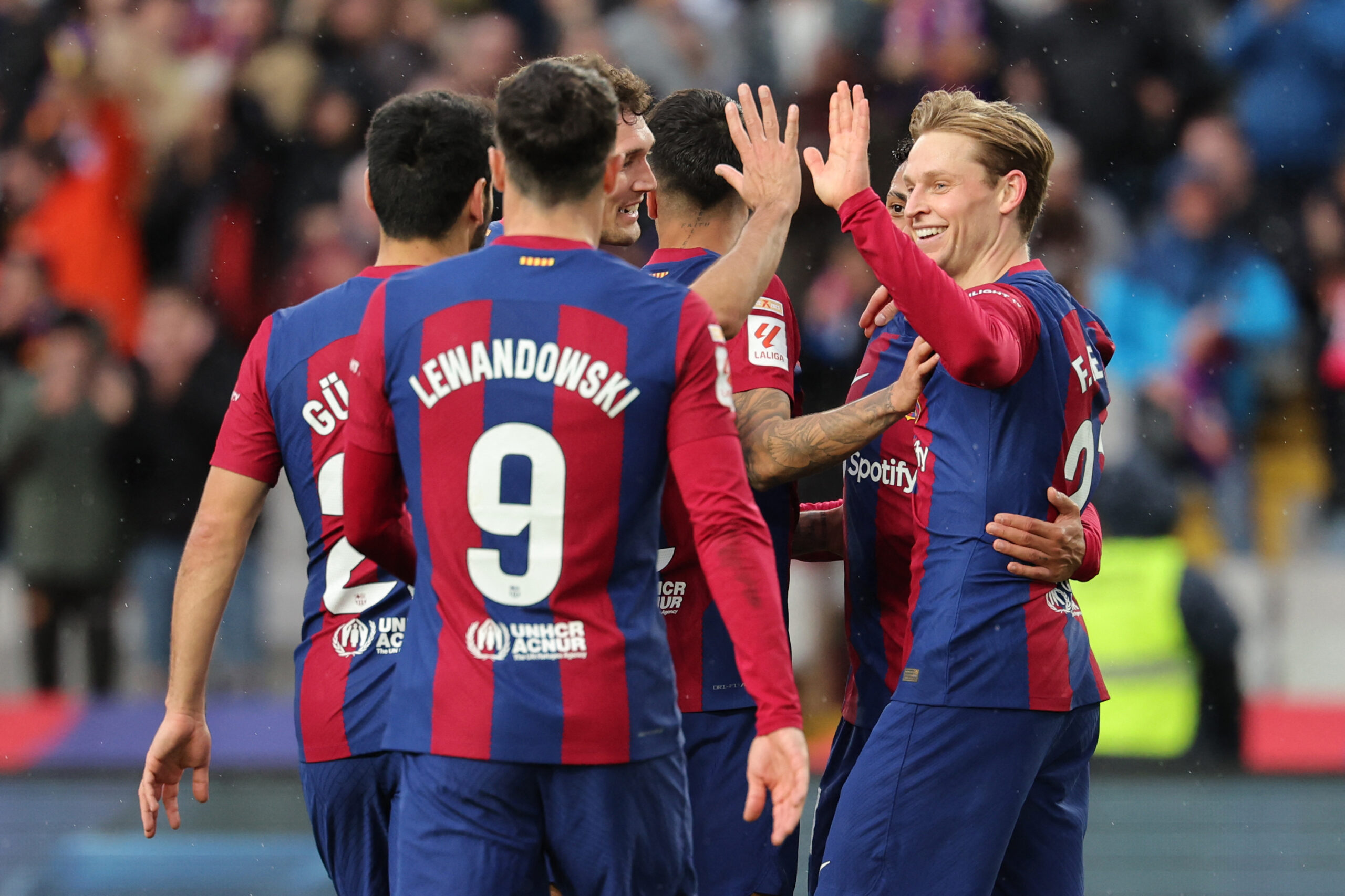 Barcelona's Dutch midfielder #21 Frenkie de Jong (R) celebrates with teammates scoring his team's third goal with teammates during the Spanish league football match between FC Barcelona and Getafe CF at the Estadi Olimpic Lluis Companys in Barcelona on February 24, 2024.