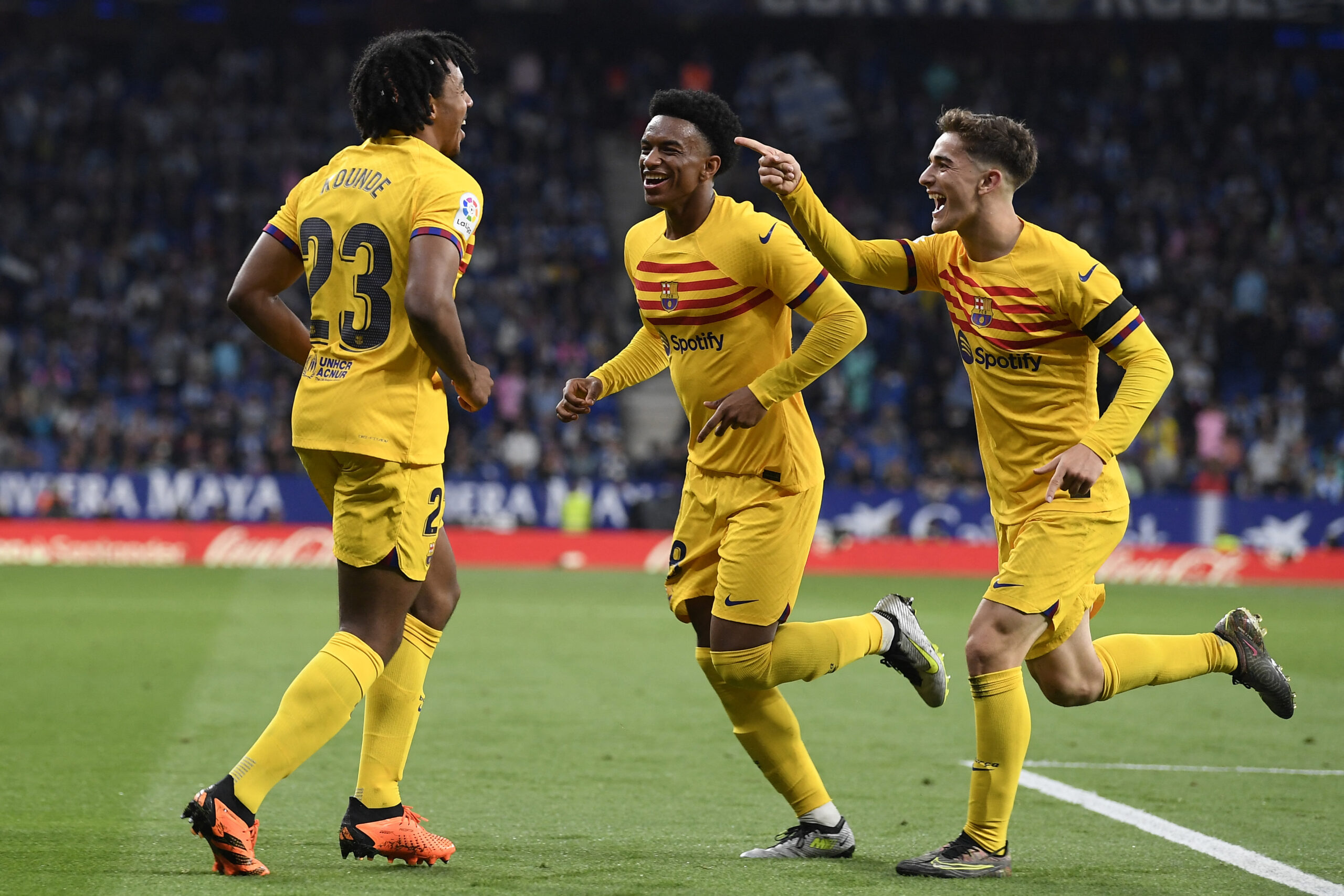 Barcelona's French defender Jules Kounde (L) celebrates scoring his team's fourth goal with Barcelona's Spanish defender Alejandro Balde (C) and Barcelona's Spanish midfielder Gavi during the Spanish league football match between RCD Espanyol and FC Barcelona at the RCDE Stadium in Cornella de Llobregat on May 14, 2023.