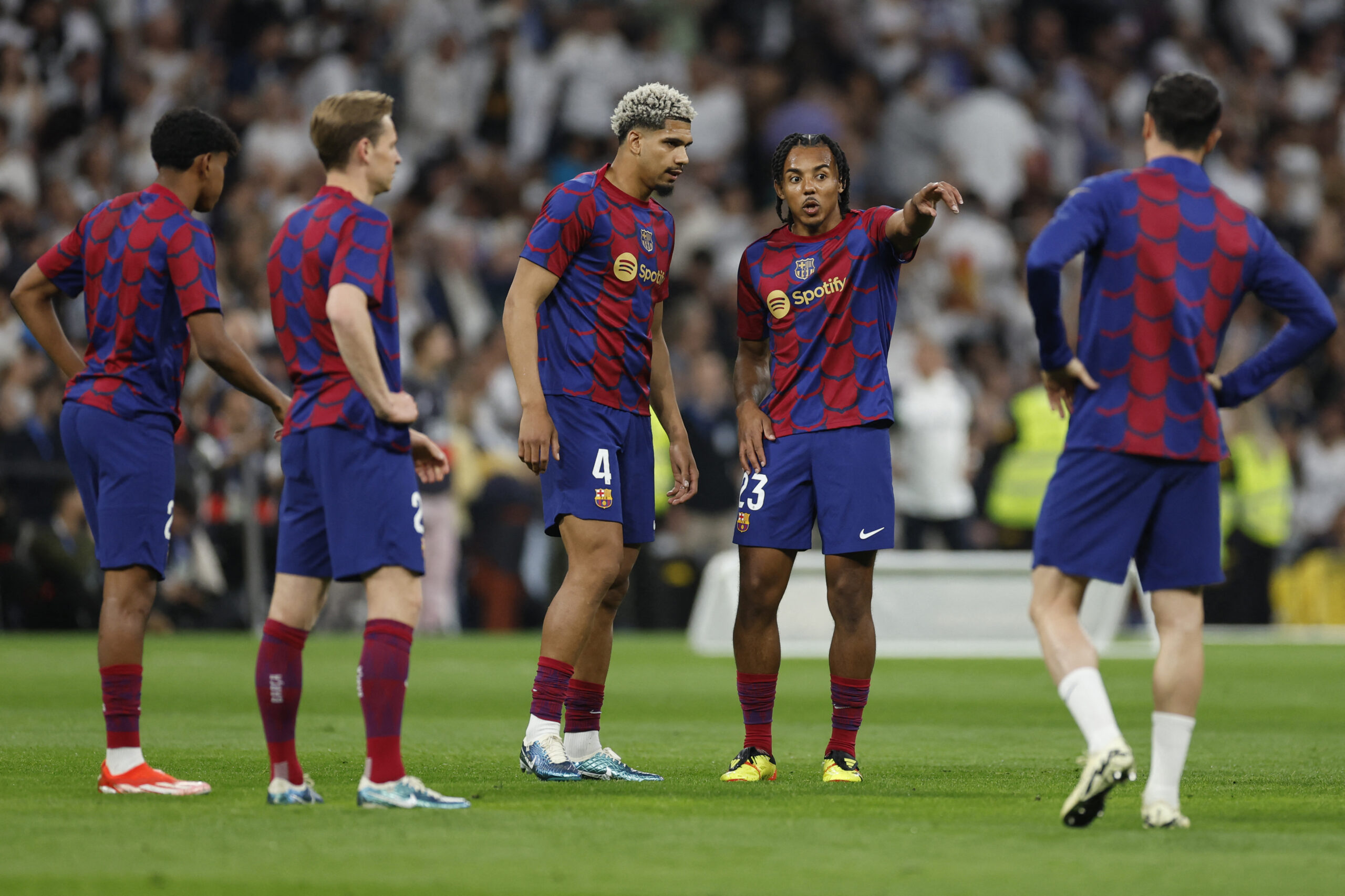 Barcelona's French defender #23 Jules Kounde and Barcelona's Uruguayan defender #04 Ronald Araujo talk during the warming up before the Spanish league football match between Real Madrid CF and FC Barcelona at the Santiago Bernabeu stadium in Madrid on April 21, 2024.