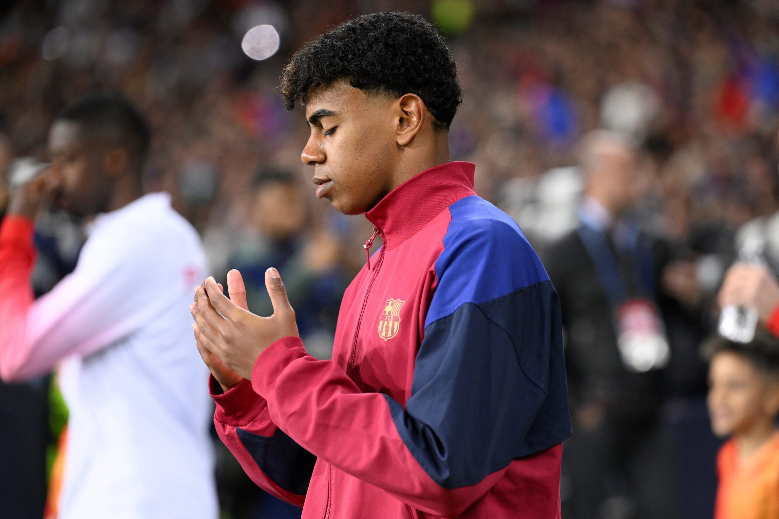 Barcelona's Spanish forward #27 Lamine Yamal prays as he enters the pitch during the UEFA Champions League quarter-final second leg football match between FC Barcelona and Paris SG at the Estadi Olimpic Lluis Companys in Barcelona on April 16, 2024.