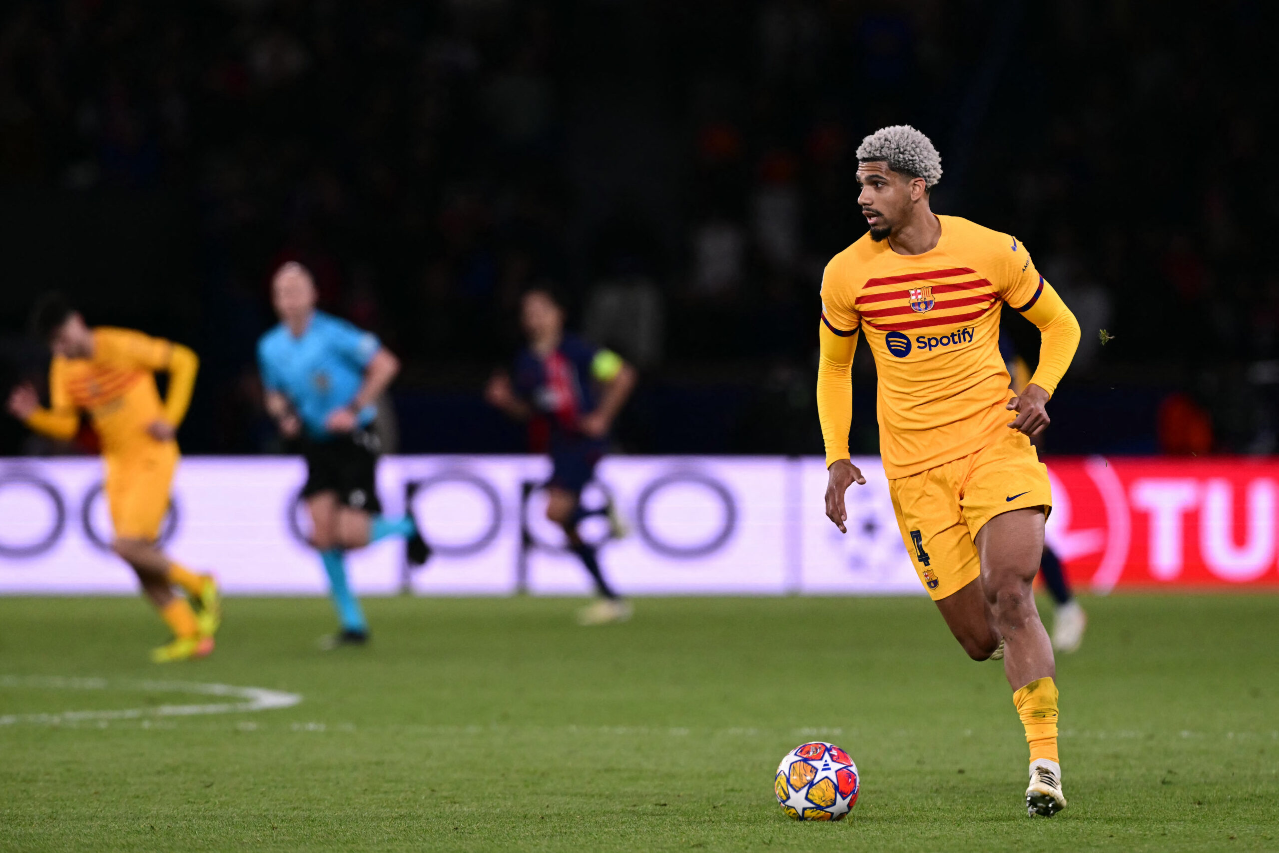 Barcelona defender #04 Ronald Araujo (R) runs with the ball during the UEFA Champions League quarter final first leg football match between Paris Saint-Germain (PSG) and FC Barcelona at the Parc des Princes stadium in Paris on April 10, 2024.