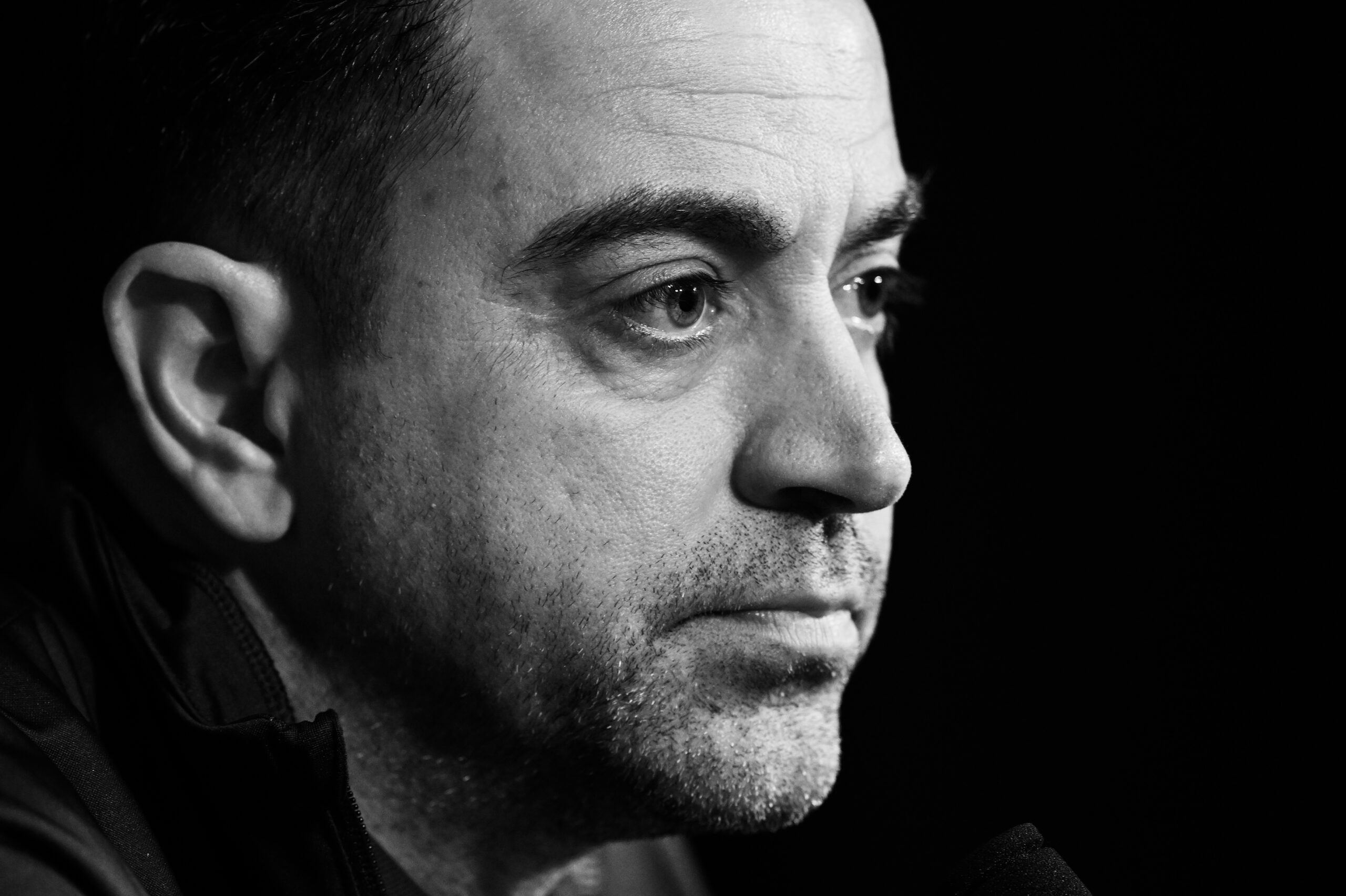 PARIS, FRANCE - APRIL 09: (EDITORS NOTE: Image has been converted to black and white.) Xavi, head coach of Barcelona talks with the media during a press conference at Parc des Princes on April 09, 2024 in Paris, France.