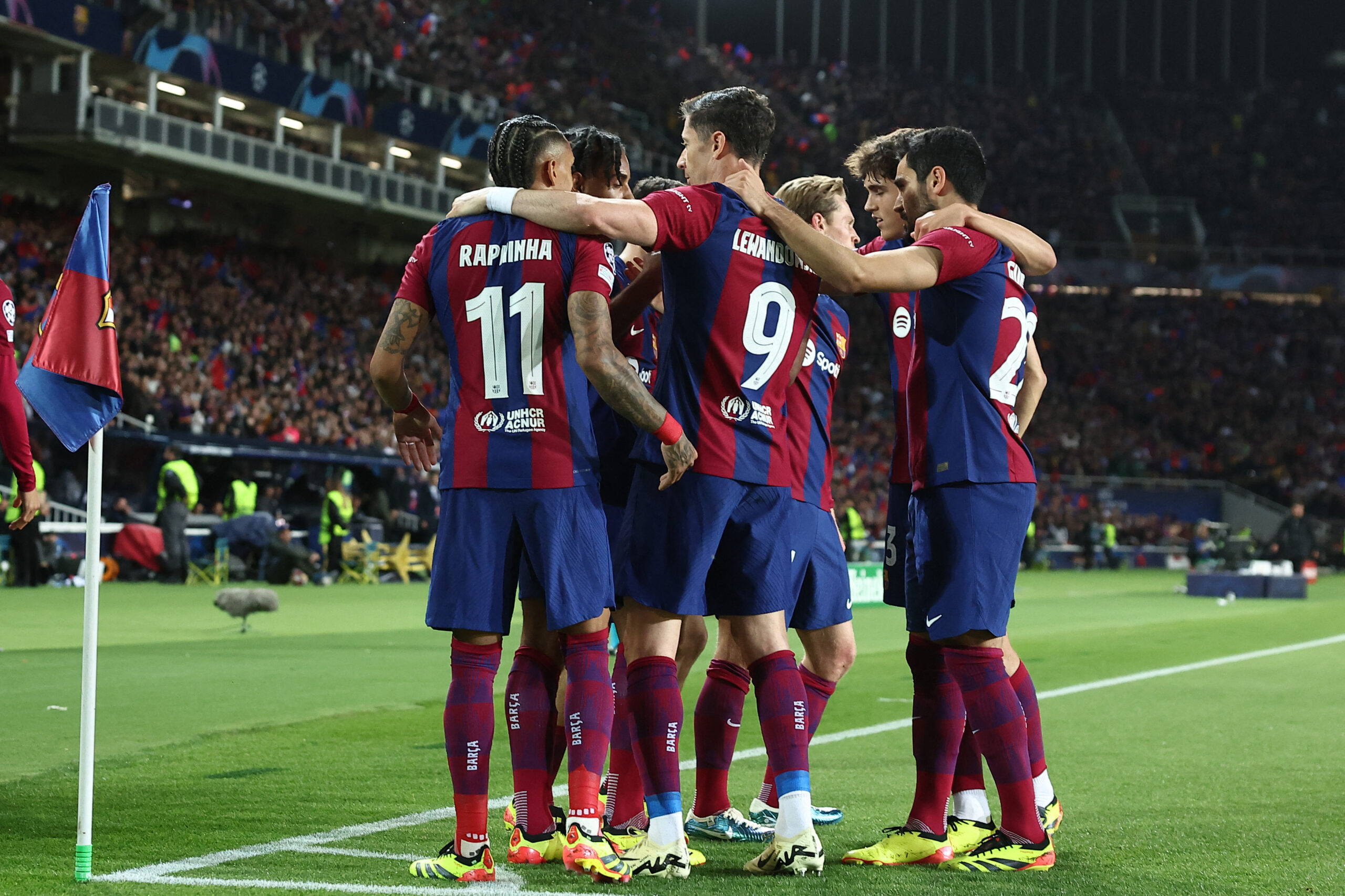 Barcelona's Brazilian forward #11 Raphinha celebrates with teammates after scoring his team's first goal during the UEFA Champions League quarter-final second leg football match between FC Barcelona and Paris SG at the Estadi Olimpic Lluis Companys in Barcelona on April 16, 2024.