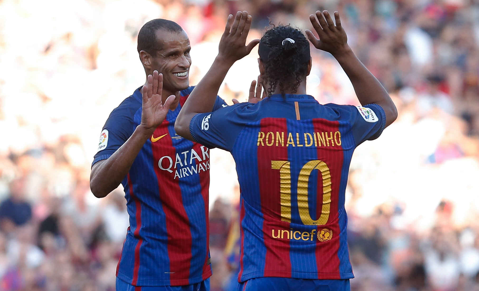 Former Barcelona's Brazilian forward Ronaldinho (R) and former Barcelona's Brazilian midfielder Rivaldo celebrate during a charity football match between Barcelona Legends vs Manchester United Legends at the Camp Nou stadium in Barcelona on June 30, 2017.
