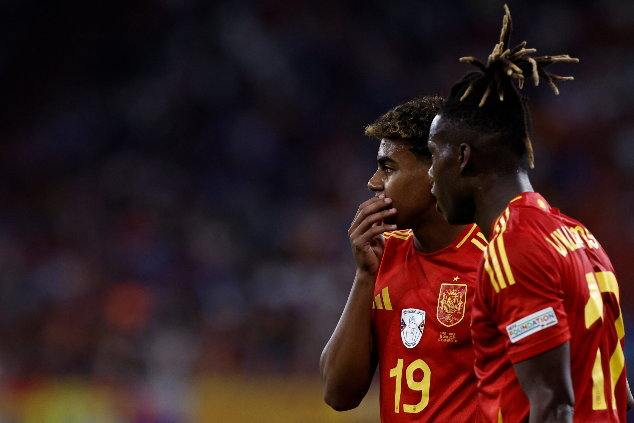 Spain's midfielder #17 Nico Williams (R) speaks with Spain's forward #19 Lamine Yamal during the UEFA Euro 2024 Group B football match between Spain and Italy at the Arena AufSchalke in Gelsenkirchen on June 20, 2024.