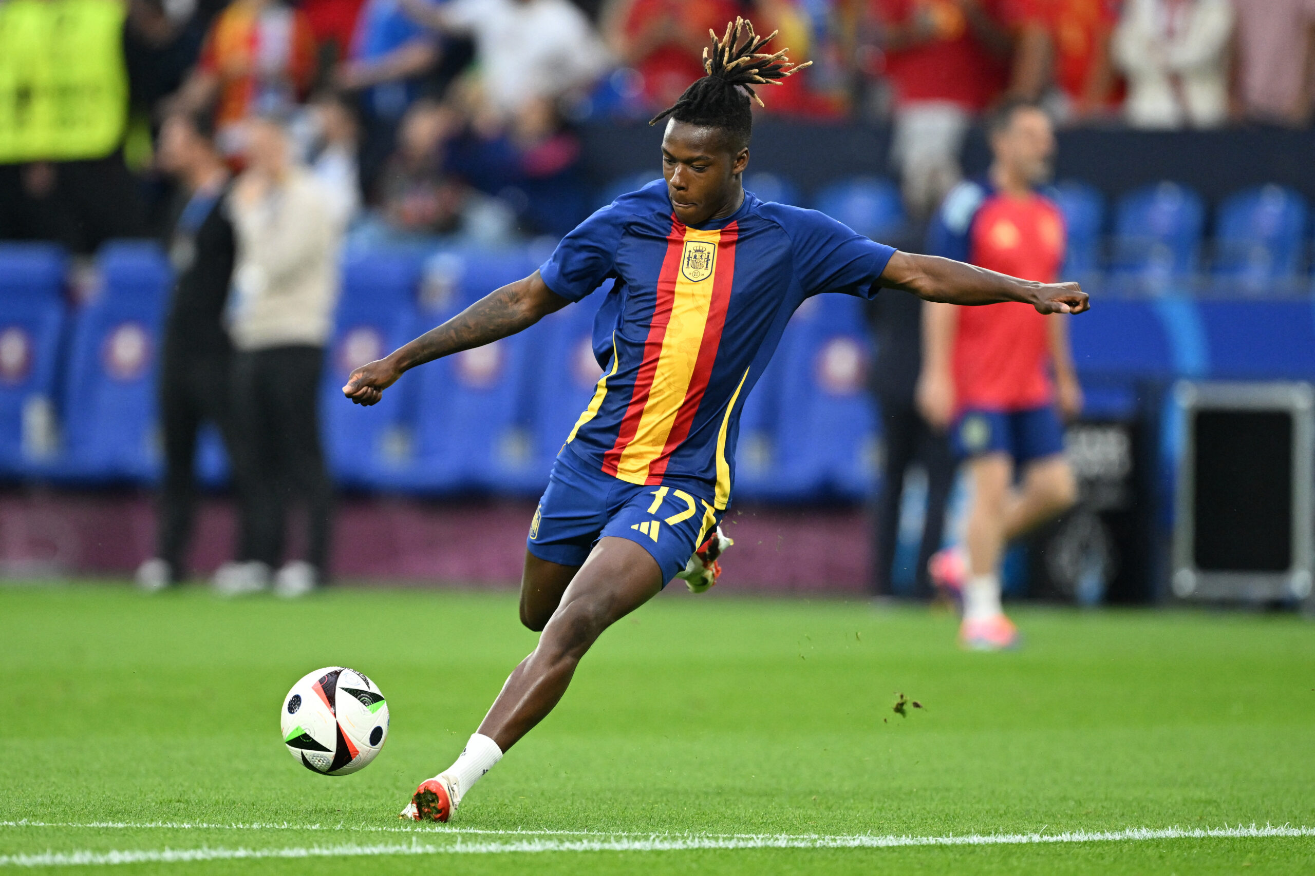 Spain's winger #17 Nico Williams warms up ahead of the UEFA Euro 2024 Group B football match between Spain and Italy at the Arena AufSchalke in Gelsenkirchen on June 20, 2024.