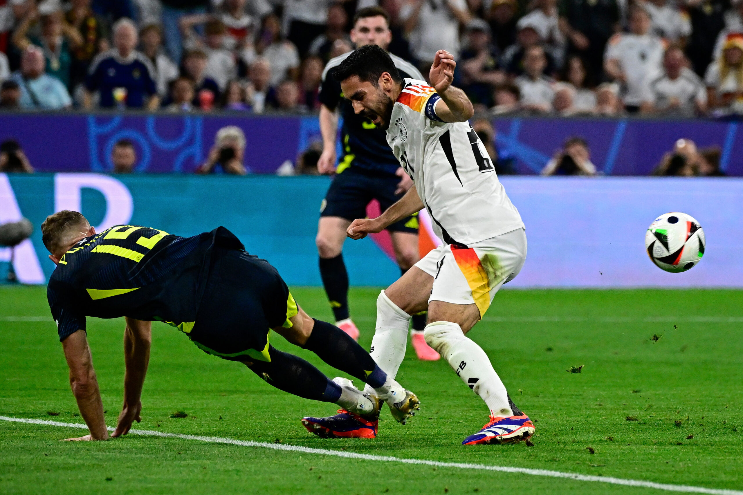 TOPSHOT - Scotland's defender #15 Ryan Porteous (L) fouls Germany's midfielder #21 Ilkay Gundogan (R) for a penalty and a red card during the UEFA Euro 2024 Group A football match between Germany and Scotland at the Munich Football Arena in Munich on June 14, 2024.
