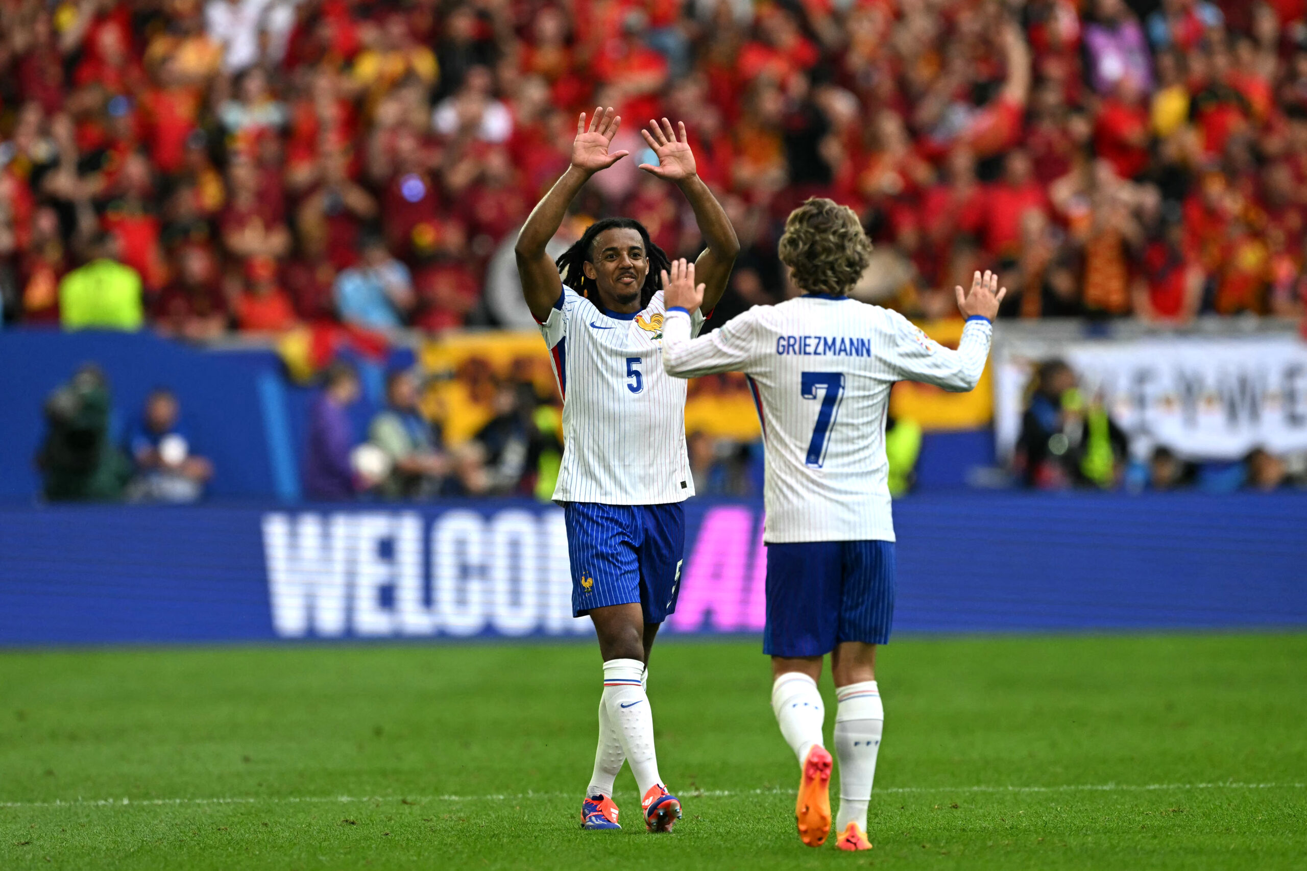 France's defender #05 Jules Kounde and midfielder #07 Antoine Griezmann celebrate their win at the end of the UEFA Euro 2024 round of 16 football match between France and Belgium at the Duesseldorf Arena in Duesseldorf on July 1, 2024.