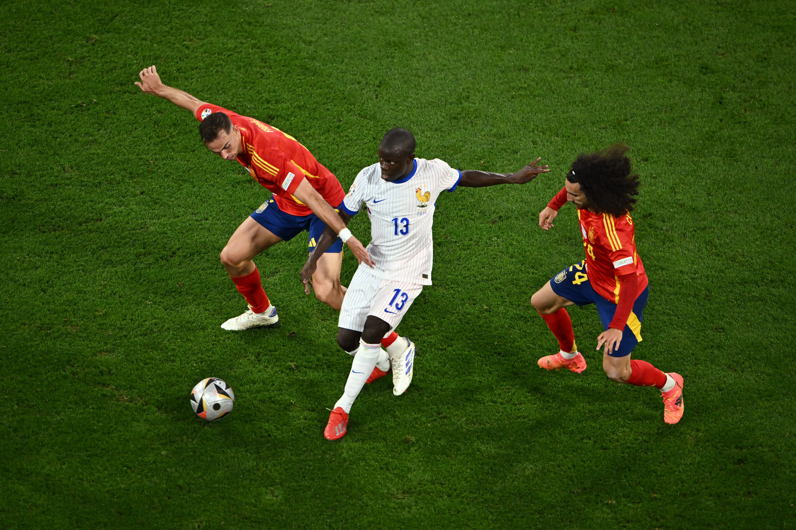 MUNICH, GERMANY - JULY 09: N'Golo Kante of France controls the ball whilst under pressure from Fabian Ruiz and Marc Cucurella of Spain during the UEFA EURO 2024 Semi-Final match between Spain and France at Munich Football Arena on July 09, 2024 in Munich, Germany.